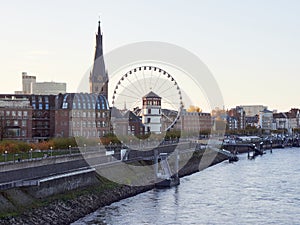 Panorama view of the city of Dusseldorf from the Rhine in Germany. Skyline of the old town with Ferris wheel at sunrise