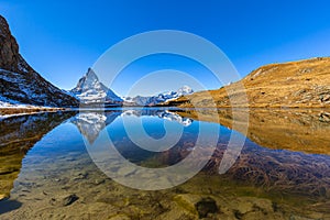 Panorama view of the famous Matterhorn and Swiss Pennine Alps with beautiful reflection in Riffelsee lake