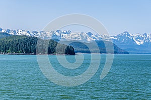 A panorama view of the forested islets and mountain backdrop of the Gastineau Channel on the approach to Juneau, Alaska