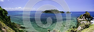 Panorama view from hill top at Kapas Island, Terengganu, Malaysia surrounded by crystal clear water, coral, island and blue sky