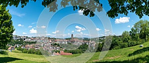 Panorama view of the historic Swiss city of Fribourg with its old town and many bridges and cathedral framed by green leaves