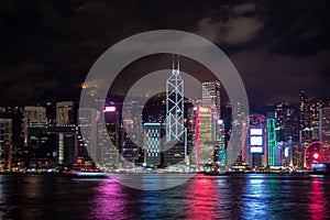 Panorama view of Hong kong city midtown at dusk with skyscrapers illuminated reflecting in the river