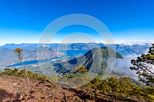 Panorama view of Lake Atitlan and volcano San Pedro and Toliman early in the morning from peak of volcano Atitlan, Guatemala. Hike