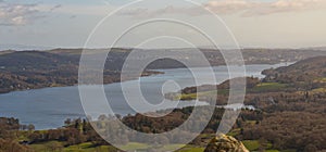 Panorama view of Lake Windermere in the Lake District, the UK surrounded by trees under the sky