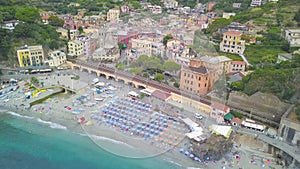 Panorama view of Monterosso al Mare village one of Cinque Terre in La Spezia, Italy. Flight along the beach, umbrellas, people