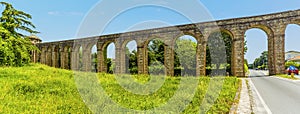 A panorama view of the Nottolini aqueduct crossing a residential road in Lucca Italy