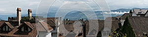 Panorama view of old houses and rooftops in Europe with mountain landscape behind