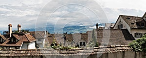 Panorama view of old houses and rooftops in Europe with mountain landscape behind