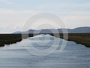 Panorama view of river channel canal at Uros Floating reed Islands on blue Lake Titicaca Puno Peru andes South America