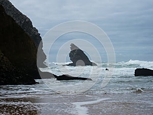 Panorama view of sea stack rock formation cliff at Praia de Adraga rough atlantic ocean coast wind storm Lisbon Portugal