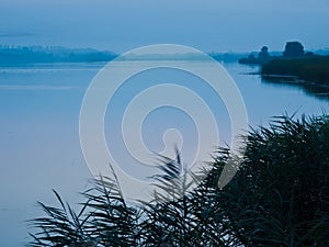 Small countryside lake on a quiet and peaceul early night in the summer, landscape background photo