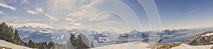 Panorama view of Swiss Alps mountai in winter with forest and blue sky