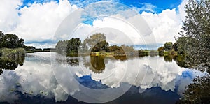 Panorama view of the town Zoeterwoude-dorp with reflection of the beautiful cloudy skies in the water