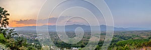 Panorama view of the village at sunset. The landscape view of a small village situated on a green hill in a valley surrounded by