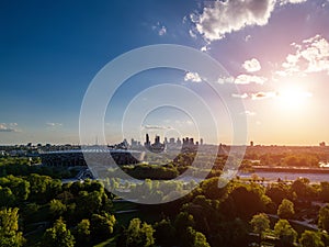panorama of Warsaw city skyline and PGE Narodowy stadium at sunset, skyscrapers of downtown and green park, aerial top photo