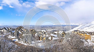 Panorama Wasatch Mountains in winter with homes on a neighborhood amid nature scenery