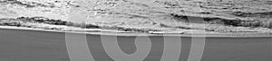 Panorama of wavelets cresting on unmarred sandy beach