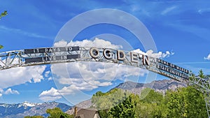 Panorama Welcome arch at the city of Ogden Utah against vivid blue sky and puffy clouds