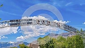 Panorama Welcome arch at the city of Ogden Utah against vivid blue sky and puffy clouds photo