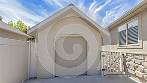 Panorama Whispy white clouds Tool shed with clipped edge entrance and sectional door