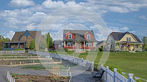 Panorama White puffy clouds Community garden with white picket fence in a residential area a