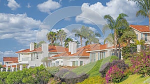 Panorama White puffy clouds Residential homes with orange bricks roofs and palm trees at Sou