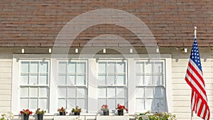 Panorama White puffy clouds Small traditional gable house with USA flag at the front in La J