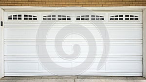 Panorama White sectional garage door with window panels and concrete driveway