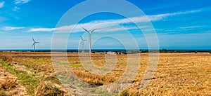 panorama of the wind farm with the Baltic Sea in the background. windmills growing out of the field. The field after the harvest