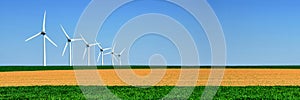 Panorama of wind turbines aligned in a field