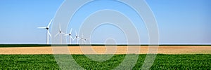 Panorama of wind turbines aligned in a field