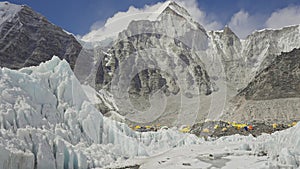 Panorama. Yellow tents at Everest Base Camp in snow mountains. Khumbu glacier