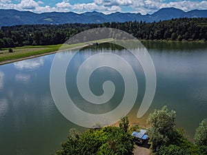 Panorama of Zovnesko jezero or Zovnek lake in Slovenia, on a hot summer day. Visible parked adventure camper van on the peninsula