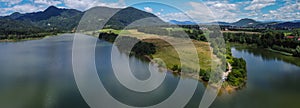 Panorama of Zovnesko jezero or Zovnek lake in Slovenia, on a hot summer day. Visible parked adventure camper van on the peninsula