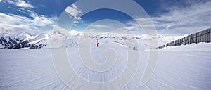 Panoramaview to ski slopes and skiers skiing in Kitzbuehel mountain ski resort with a background to Alps in Austria photo