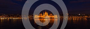 Panoramic aerial drone shot of Hungarian Parliament with lights on during Budapest evening