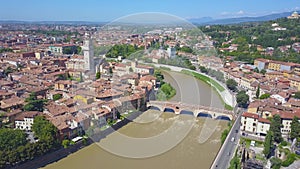 Panoramic aerial drone view of Verona, Italy. The drone flies over the river Adige, typical Italian apartment rooftops and bridge