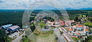 Panoramic aerial drone view of a white mosque known as Tun Khalil Mosque with Mount Ledang background at Asahan, Melaka, Malaysia.