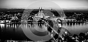 Panoramic aerial night landscape of the gothic catholic Cologne cathedral, Hohenzollern Bridge and the River Rhine in Cologne, Ger