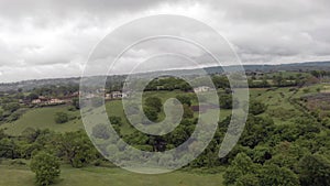 Panoramic aerial shot of the countryside with green hills, meadows and forests