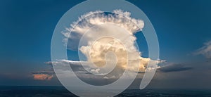 Panoramic aerial shot of cumulonimbus capillatus, a huge storm cloud against a blue sky.