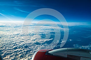 Panoramic aerial view. Beautiful sunset sky above clouds with dramatic light. Cabin view from airplane. Passenger airliner.