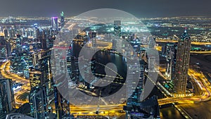 Panoramic aerial view of business bay towers in Dubai night timelapse.