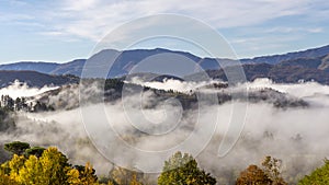 Panoramic aerial view of Garfagnana partially covered by early morning fog, Lucca, Tuscany, Italy