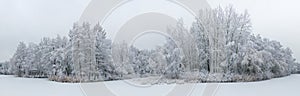 Panoramic aerial view of winter beautiful landscape with trees covered with hoarfrost and snow. Winter scenery from above.