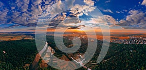 Panoramic air view of colorful hot air ballons flying over park and river in small european city at summer sunset