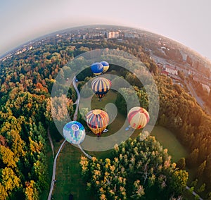 Panoramic air view of hot air ballons prepare for an early morning takeoff from park in small european city