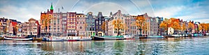 Panoramic autumn view of Amsterdam city. Famous Dutch channels and great cityscape. Colorful morning scene of Netherlands, Europe.