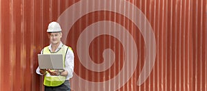 Panoramic banner. caucasian white engineer control worker working on digital laptop computer with cargo container in background at
