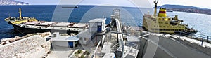 A panoramic banner of a large cargo ship in the Aegean Sea dock, located in Milos island, Greece.